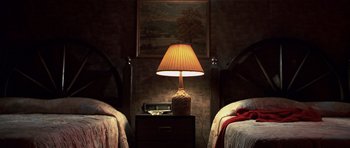 Movie still from “Joy Ride” (2001), directed by John Dahl – A lamp on a nightstand next to two beds in a bedroom; Wide shot, Overhead angle