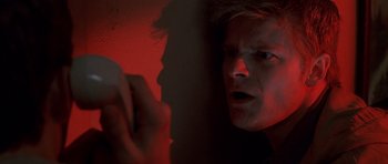 Movie still from “Joy Ride” (2001), directed by John Dahl – A man with a surprised look on his face in a dark room; Close Up shot, Low angle