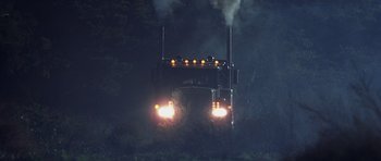 Movie still from “Joy Ride” (2001), directed by John Dahl – A semi truck is driving down the road at night; Wide shot, Low angle