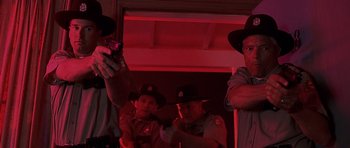 Movie still from “Joy Ride” (2001), directed by John Dahl – A group of men standing next to each other in a room; Medium shot, Low angle