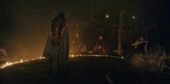 Movie still from “Barbarians” (2020), created by Arne Nolting – A group of people sitting in a dark room; Wide shot, Low angle