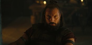 Movie still from “Barbarians” (2020), created by Arne Nolting – A man with long hair and a beard is looking at the camera; Close Up shot, Over the shoulder angle