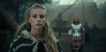 Movie still from “Barbarians” (2020), created by Arne Nolting – A woman with long blonde hair wearing a black and white coat; Close Up shot, Low angle
