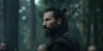 Movie still from “Barbarians” (2020), created by Arne Nolting – A man with long black hair and a long beard; Close Up shot, Over the shoulder angle