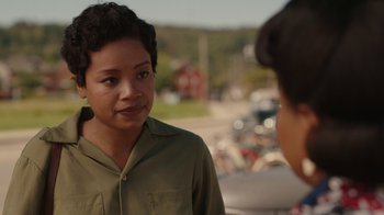 Movie still from “A League of Their Own” (2022), created by Abbi Jacobson – A woman in a green shirt talking to a man in a green shirt; Close Up shot, Over the shoulder angle
