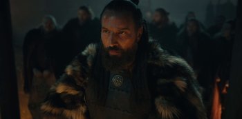 Movie still from “Barbarians” (2020), created by Arne Nolting – A man with a beard wearing a fur coat; Close Up shot, Low angle