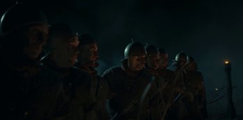 Movie still from “Barbarians” (2020), created by Arne Nolting – A group of men in military uniforms standing next to each other in the dark; Medium shot, Low angle