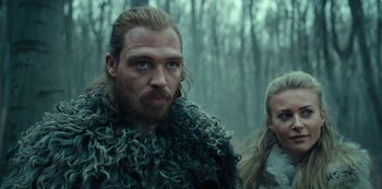 Movie still from “Barbarians” (2020), created by Arne Nolting – A man and a woman are standing in the woods; Close Up shot, Low angle