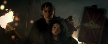 Movie still from “Pompeii” (2014), directed by Paul W.S. Anderson – A woman standing next to a young girl in front of a fire; Close Up shot, Low angle