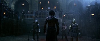 Movie still from “Pompeii” (2014), directed by Paul W.S. Anderson – A group of people in a room with fire; Wide shot, Over the shoulder angle