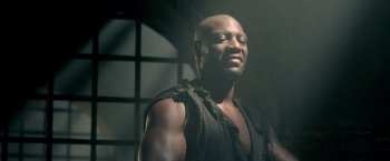 Movie still from “Pompeii” (2014), directed by Paul W.S. Anderson – A bald man with a black shirt on looking up; Close Up shot, Low angle