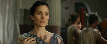 Movie still from “Pompeii” (2014), directed by Paul W.S. Anderson – A woman in a roman dress looking to her left; Close Up shot, Over the shoulder angle