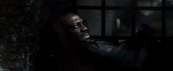 Movie still from “Pompeii” (2014), directed by Paul W.S. Anderson – A man sitting in a dark room with his eyes wide open; Close Up shot, High angle