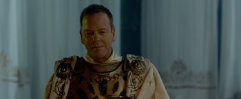 Movie still from “Pompeii” (2014), directed by Paul W.S. Anderson – A person wearing a suit of armor; Close Up shot, Over the shoulder angle