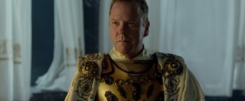 Movie still from “Pompeii” (2014), directed by Paul W.S. Anderson – A man in a gold and white outfit; Close Up shot, Over the shoulder angle
