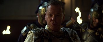 Movie still from “Pompeii” (2014), directed by Paul W.S. Anderson – A person wearing a suit of armor; Close Up shot, Over the shoulder angle