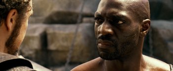 Movie still from “Pompeii” (2014), directed by Paul W.S. Anderson – A man's face in a cave; Close Up shot, Over the shoulder angle