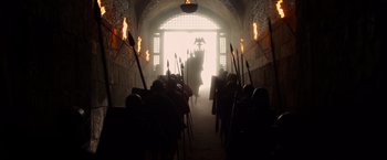 Movie still from “Pompeii” (2014), directed by Paul W.S. Anderson – A group of people walking down a hallway with torches; Extreme Wide shot, Low angle