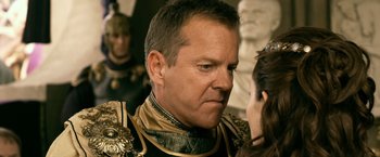 Movie still from “Pompeii” (2014), directed by Paul W.S. Anderson – A man wearing a black and gold uniform; Close Up shot, Over the shoulder angle