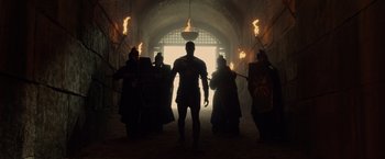 Movie still from “Pompeii” (2014), directed by Paul W.S. Anderson – A group of people are walking through a tunnel; Wide shot, Low angle