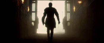 Movie still from “Pompeii” (2014), directed by Paul W.S. Anderson – A man in a suit of armor walking through a doorway; Wide shot, Low angle