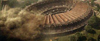 Movie still from “Pompeii” (2014), directed by Paul W.S. Anderson – An aerial view of an arena with smoke billowing out of it; Extreme Wide shot, High angle