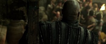 Movie still from “Pompeii” (2014), directed by Paul W.S. Anderson – A man with a bunch of hair on his head; Close Up shot, Over the shoulder angle