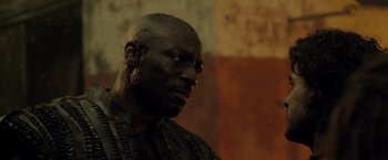 Movie still from “Pompeii” (2014), directed by Paul W.S. Anderson – A man with a black face is looking to his left; Close Up shot, Low angle