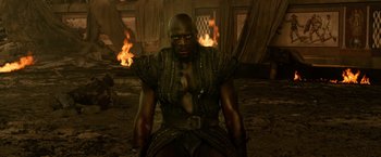 Movie still from “Pompeii” (2014), directed by Paul W.S. Anderson – A man in chains sitting in front of fire; Medium shot, High angle