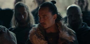 Movie still from “Barbarians” (2020), created by Arne Nolting – A man in a fur coat with a long black beard; Close Up shot, Over the shoulder angle