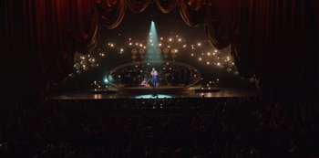 A man is standing on a stage in front of an audience