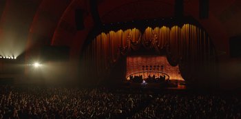 An audience is sitting in front of a stage