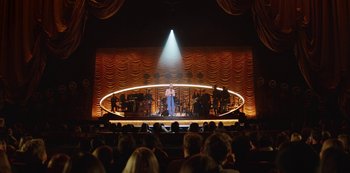 A person is singing on a stage in front of an audience