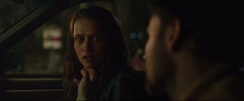 Movie still from “Berlin Syndrome” (2017), directed by Cate Shortland – A woman looking at a man in a dark room; Close Up shot, Over the shoulder angle