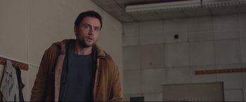 Movie still from “Berlin Syndrome” (2017), directed by Cate Shortland – A man standing in an empty room looking up at the ceiling; Medium shot, Low angle