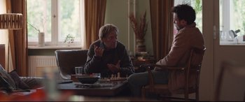 Movie still from “Berlin Syndrome” (2017), directed by Cate Shortland – Two people are sitting at a table playing chess; Medium shot, Over the shoulder angle