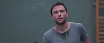 Movie still from “Berlin Syndrome” (2017), directed by Cate Shortland – A person wearing headphones and looking at the camera; Close Up shot, Low angle