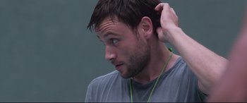 Movie still from “Berlin Syndrome” (2017), directed by Cate Shortland – A person with a green cord on his ear; Close Up shot, Over the shoulder angle