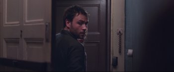 Movie still from “Berlin Syndrome” (2017), directed by Cate Shortland – A man standing in front of an open door; Close Up shot, Over the shoulder angle
