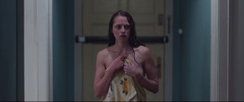 Movie still from “Berlin Syndrome” (2017), directed by Cate Shortland – A woman wrapped in a towel in a bathroom; Medium shot, Low angle