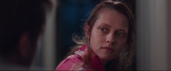 Movie still from “Berlin Syndrome” (2017), directed by Cate Shortland – A young girl in a pink shirt is looking at the camera; Close Up shot, Over the shoulder angle