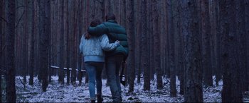 Movie still from “Berlin Syndrome” (2017), directed by Cate Shortland – Two people walking in the woods holding each other; Wide shot, Low angle