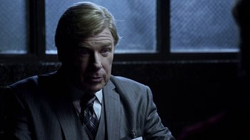 Movie still from “Better Call Saul” (2015), created by Vince Gilligan – A man in a suit and tie sitting in front of a window; Close Up shot, Over the shoulder angle