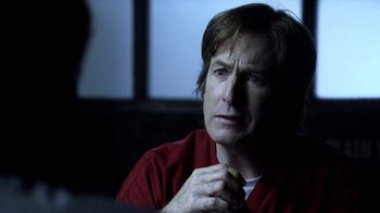 Movie still from “Better Call Saul” (2015), created by Vince Gilligan – A man in a red shirt holding his chin in his hands; Close Up shot, Over the shoulder angle