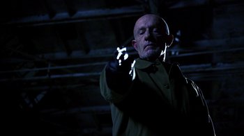 Movie still from “Better Call Saul” (2015), created by Vince Gilligan – A man in a green jacket is holding something in his hand; Close Up shot, Low angle