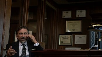 Movie still from “Better Call Saul” (2015), created by Vince Gilligan – A man sitting in a chair talking on a cell phone; Medium shot, Over the shoulder angle