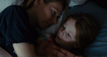 Movie still from “Win Win” (2011), directed by Tom McCarthy – A woman and a child laying in bed together; Close Up shot, High angle