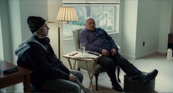 Movie still from “Win Win” (2011), directed by Tom McCarthy – Two people sitting in a chair in front of a table; Wide shot, Over the shoulder angle