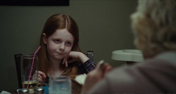 Movie still from “Win Win” (2011), directed by Tom McCarthy – A young girl sitting at a table with her hand on her chin; Close Up shot, Over the shoulder angle