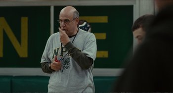 Movie still from “Win Win” (2011), directed by Tom McCarthy – An older man with glasses is holding something in his mouth; Close Up shot, Low angle